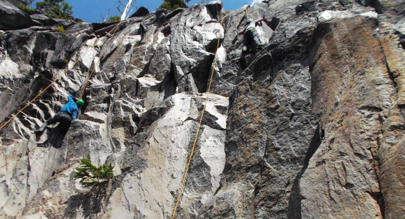 a person wearing safety gear climbs a rock wall